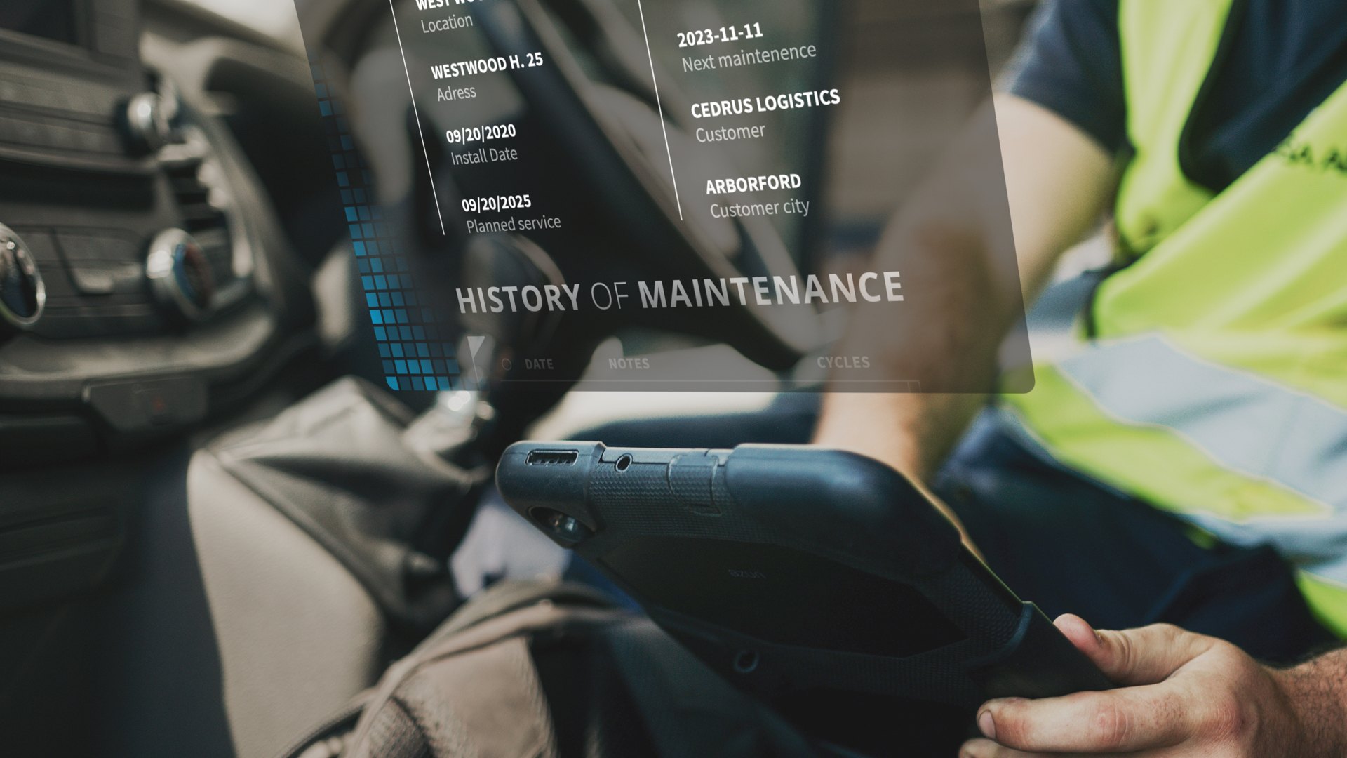 Service engineer in a hi-vis vest using a tablet to check a system maintenance history