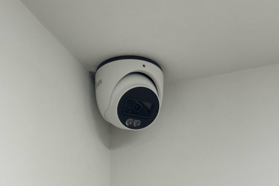 White turret CCTV camera mounted in the corner of an office ceiling