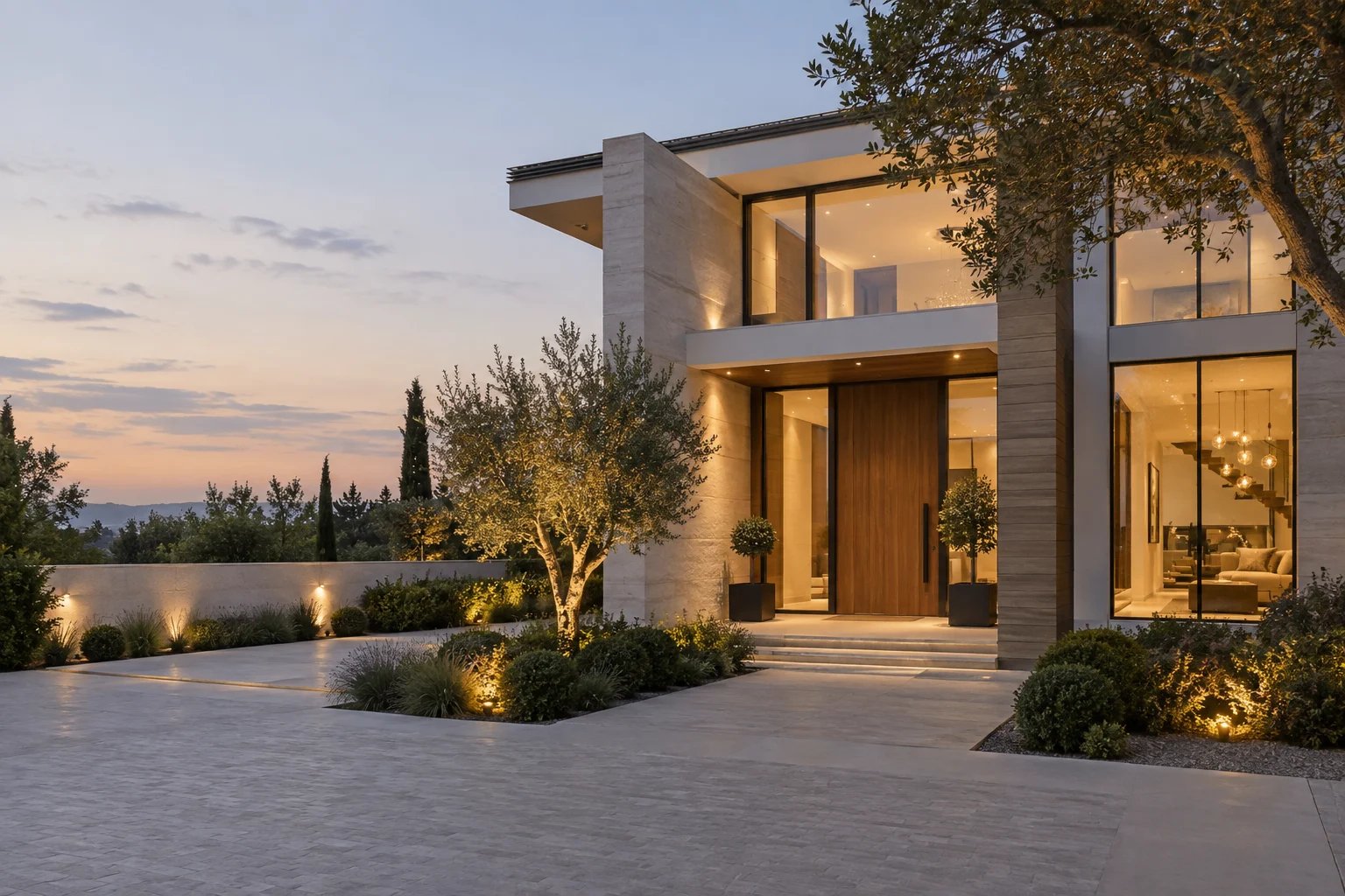 Contemporary home entrance with pale stone, timber and warm evening lighting