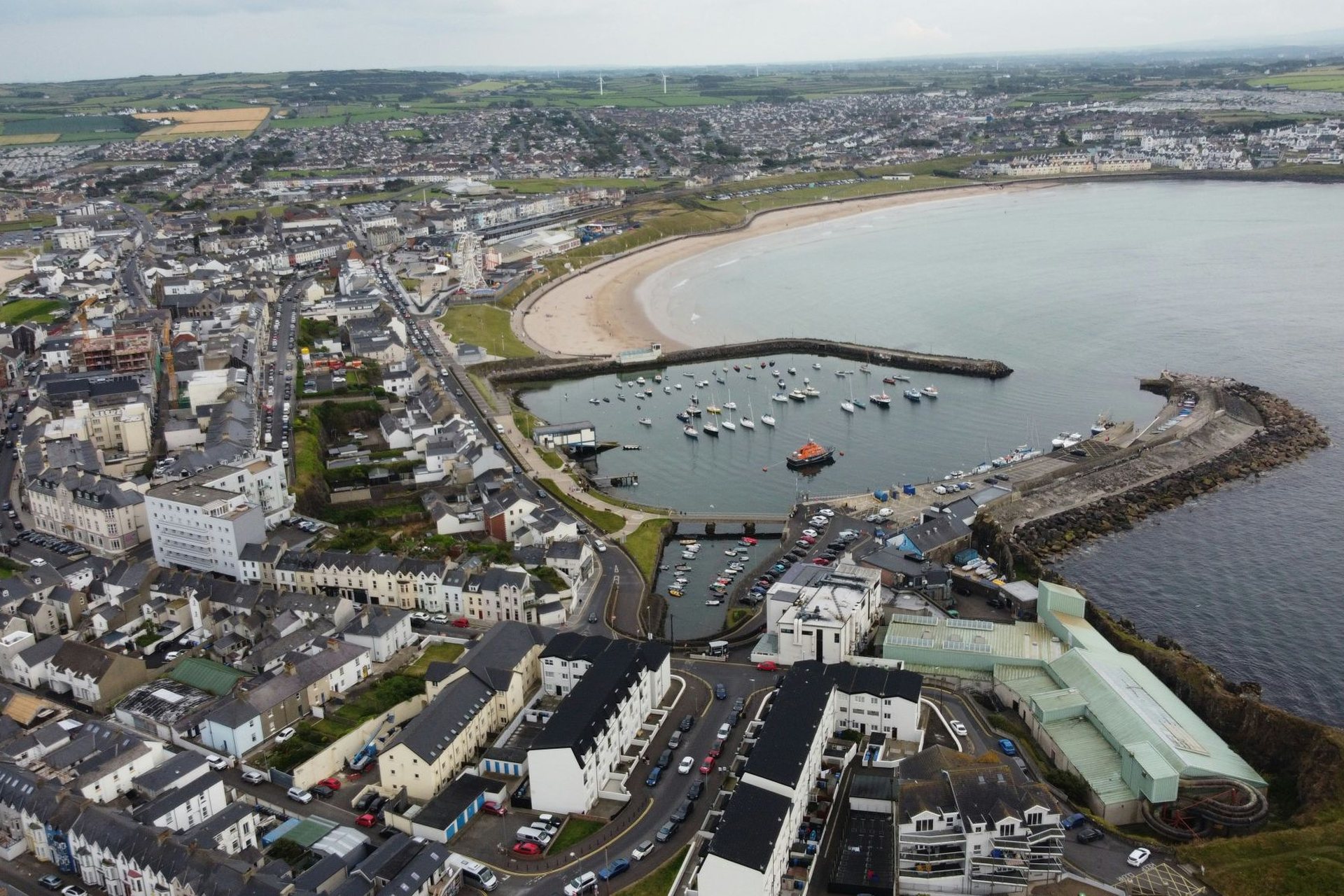 Aerial view of Portrush harbour, beach and town